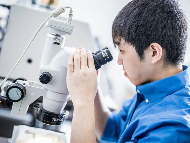 Scientist looking through microscope